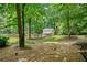Backyard with a stone path leading to a deck and small barn-like structure surrounded by lush trees at 3372 English Oaks Nw Dr, Kennesaw, GA 30144