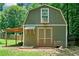 Exterior of small barn with a double door and window and small lawnmower nearby at 3372 English Oaks Nw Dr, Kennesaw, GA 30144