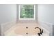 Close-up of bathtub with a black faucet, surrounded by a marble tiled wall at 3372 English Oaks Nw Dr, Kennesaw, GA 30144