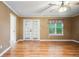 Spacious living room with hardwood floors, ceiling fan, and natural light from the doors and window at 3372 English Oaks Nw Dr, Kennesaw, GA 30144