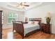 Comfortable main bedroom with hardwood floors, tray ceiling, and a large window at 3372 English Oaks Nw Dr, Kennesaw, GA 30144