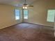 Bedroom with carpeted floors, ceiling fan, and three windows offering natural light at 5040 Brittany Dr, Stone Mountain, GA 30083