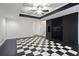A finished basement with a black accent wall and black and white checkered flooring at 5059 Winding Hills Lane Ln, Woodstock, GA 30189