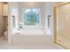 Bright bathroom with a soaking tub, decorative window, and a glass-enclosed shower at 5059 Winding Hills Lane Ln, Woodstock, GA 30189