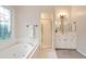 Elegant bathroom featuring a soaking tub, glass-enclosed shower, and decorative window at 5059 Winding Hills Lane Ln, Woodstock, GA 30189
