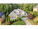 Well-manicured lawn and mature trees surround this beautiful two-story home with a neutral color scheme at 5059 Winding Hills Lane Ln, Woodstock, GA 30189