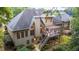 View of home's back exterior featuring a spacious deck with outdoor seating, and lush landscaping at 5059 Winding Hills Lane Ln, Woodstock, GA 30189