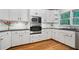 Bright kitchen with stainless appliances, tile backsplash, and light wood floors at 5059 Winding Hills Lane Ln, Woodstock, GA 30189