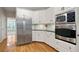 Well-lit kitchen with stainless steel appliances, wood floors, and white cabinets at 5059 Winding Hills Lane Ln, Woodstock, GA 30189