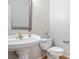 Charming powder room featuring a pedestal sink, decorative mirror, and updated fixtures at 5059 Winding Hills Lane Ln, Woodstock, GA 30189