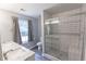 Modern bathroom featuring double vanity, tiled shower with glass door, and a window for natural light at 706 Hillmont Dr, Loganville, GA 30052