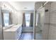 Bright bathroom featuring a double vanity, a glass shower with subway tile, and a large mirror at 706 Hillmont Dr, Loganville, GA 30052