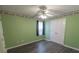 Green bedroom with gray vinyl flooring, ceiling fan, a window, and closet with double doors at 706 Hillmont Dr, Loganville, GA 30052