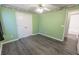 Green bedroom featuring hard floors, a window and two doors leading to other rooms at 706 Hillmont Dr, Loganville, GA 30052