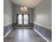 Bright dining room featuring gray walls, decorative molding, wood-look flooring, and a modern chandelier at 706 Hillmont Dr, Loganville, GA 30052