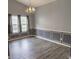 Elegant dining room featuring modern gray tones, a chandelier, and ample natural light through large windows at 706 Hillmont Dr, Loganville, GA 30052