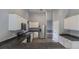 Stylish kitchen featuring white cabinets, stainless steel appliances, dark countertops, and modern wood-look floors at 706 Hillmont Dr, Loganville, GA 30052