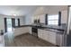 Modern kitchen featuring white cabinets, stainless steel appliances, dark countertops, and wood-look flooring at 706 Hillmont Dr, Loganville, GA 30052