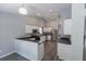 Bright kitchen with white cabinets, stainless steel appliances, dark countertops, and wood-look flooring at 706 Hillmont Dr, Loganville, GA 30052