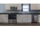 Close up of kitchen featuring stainless steel appliances, white cabinets, and dark countertops at 706 Hillmont Dr, Loganville, GA 30052