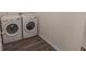 Convenient laundry room featuring new gray flooring and efficient, front-loading washer and dryer units at 706 Hillmont Dr, Loganville, GA 30052
