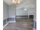 Open-concept living room with fireplace, gray walls with molding, wood-look flooring, and a view of the dining area at 706 Hillmont Dr, Loganville, GA 30052