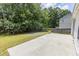 Backyard concrete patio with lush greenery, perfect for outdoor entertaining and relaxation in a private setting at 706 Hillmont Dr, Loganville, GA 30052
