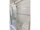 Modern shower with subway tile, hexagon tile floor, glass doors and built in bench at 706 Hillmont Dr, Loganville, GA 30052