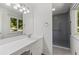 Bright bathroom featuring modern vanity, mirror, tile floor, and a glass-enclosed shower at 880 Winfield Sw Ct, Marietta, GA 30060