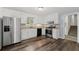 Features an updated kitchen with white cabinets, stainless steel appliances and luxury vinyl flooring at 880 Winfield Sw Ct, Marietta, GA 30060