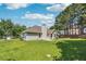 The exterior view of home with lush green grass, mature trees, and well maintained landscaping at 2410 Napa Valley Dr, Villa Rica, GA 30180