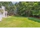 Well-maintained backyard with lush green grass, mature trees, and a patio at 2410 Napa Valley Dr, Villa Rica, GA 30180