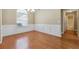 Bright dining room with hardwood floors, wainscoting, and a view of the backyard at 2410 Napa Valley Dr, Villa Rica, GA 30180