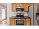 Kitchen with stainless steel appliances, wood cabinets, and black countertops at 2410 Napa Valley Dr, Villa Rica, GA 30180