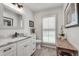 Bright bathroom with white cabinets, marble countertop, and window with plantation shutters at 2936 Randolph Ne Rd, Atlanta, GA 30345