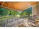 Inviting covered back porch with rocking chairs, overlooking a spacious, fenced backyard with mature trees at 3540 Pilgrim Mill Rd, Cumming, GA 30041