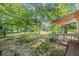 A serene backyard with mature trees and a covered patio offering an ideal space for relaxation at 3540 Pilgrim Mill Rd, Cumming, GA 30041