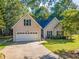 Charming home featuring a two-car garage and a well-maintained lawn, nestled among mature trees at 3540 Pilgrim Mill Rd, Cumming, GA 30041