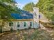 View of rear exterior showing a spacious yard and deck, surrounded by mature trees at 3540 Pilgrim Mill Rd, Cumming, GA 30041