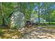 Outdoor shed with double doors, accompanied by lawn equipment and trailer in a shaded yard at 3540 Pilgrim Mill Rd, Cumming, GA 30041
