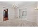 Open-concept dining room with plush carpeting, chandelier lighting, and views into the kitchen at 626 Cheatham Sw Dr, Marietta, GA 30064