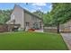 A home's backyard with artificial grass, patio seating and a grill, perfect for outdoor living at 1019 Avonley Creek Trce, Sugar Hill, GA 30518