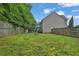 Large backyard surrounded by a wood fence with a fire pit in the middle of the yard at 1019 Avonley Creek Trce, Sugar Hill, GA 30518