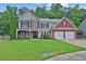 Charming two-story home boasts a brick and siding facade, lush lawn, and attached two-car garage at 1019 Avonley Creek Trce, Sugar Hill, GA 30518