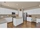 Bright kitchen with white cabinets, granite countertops, stainless appliances, and a center island with bar seating at 1019 Avonley Creek Trce, Sugar Hill, GA 30518