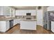 Bright kitchen with white cabinets, granite countertops, stainless appliances, and a center island with bar seating at 1019 Avonley Creek Trce, Sugar Hill, GA 30518