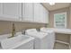 Functional laundry room with sink, ample counter space, and white cabinets for storage at 1019 Avonley Creek Trce, Sugar Hill, GA 30518