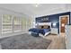 Serene main bedroom features a tray ceiling, accent wall, plush carpeting, and an ensuite bathroom at 1019 Avonley Creek Trce, Sugar Hill, GA 30518