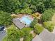 Aerial view of the community pool surrounded by lush trees and lounge chairs on a sunny day at 214 Harmony Lake Dr, Canton, GA 30115