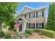 Charming brick home features manicured landscaping, covered entry, and an American flag for a welcoming curb appeal at 214 Harmony Lake Dr, Canton, GA 30115